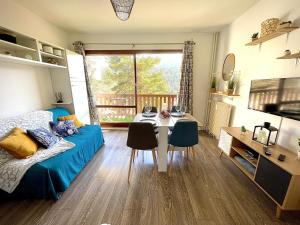 a living room with a bed and a table and chairs at U066 - Appartement cosy, vue sur la montagne à Gréolières in Gréolières