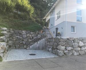 a stone retaining wall next to a house at Fewo Suggental in Buchholz