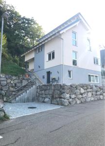 a white house with a stone wall and a building at Fewo Suggental in Buchholz
