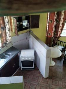 uma pequena cozinha com um lavatório e um fogão em Kikambala Eco Villas em Mombasa