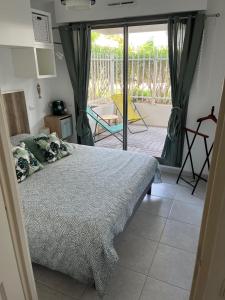a bedroom with a bed and a view of a patio at Appartement Le Cosi 2 -bord de mer- in La Ciotat