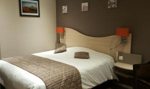 una camera con un grande letto e un lavandino di Logis Hotel au tambour a Reims