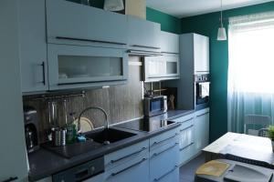 a kitchen with white cabinets and a sink at Apartament Swarzędz in Swarzędz