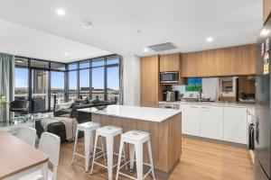 a kitchen with a counter and stools in a room at Stunning Views 2BR Luxury Pool Parking Gym WiFi in Adelaide