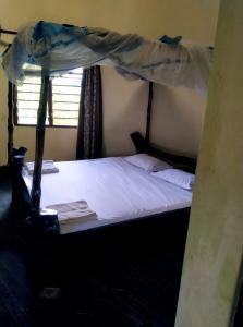 a bedroom with a bed with a canopy at Kikambala Eco Villas in Mombasa