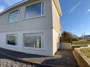 una casa con ventanas en un lateral en Waterfront Fjord House, en Litli-Árskógssandur