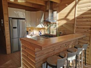 una cucina con un grande bancone in legno con sgabelli di Chalet de Charme, Cedars, Lebanon, Balcony Floor a Al Arz