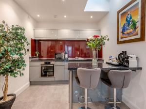 a kitchen with a counter and two stools at The Otter - Uk40927 in Holdenhurst