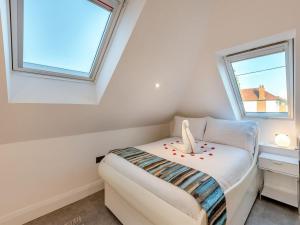 a small bedroom with a bed and two windows at The Otter - Uk40927 in Holdenhurst