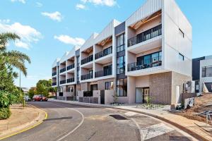 una calle vacía delante de un edificio en Jewel on Jubilee - New 1 Bed Apt with Parking en Port Adelaide