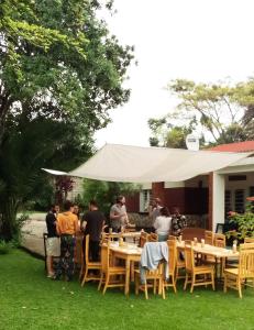 a group of people standing around tables under a white tent at COLIBRI TAVERNE Gisenyi in Gisenyi