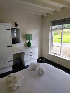 1 dormitorio con 1 cama con toallas en Corofin Lake Cottages en Corrofin