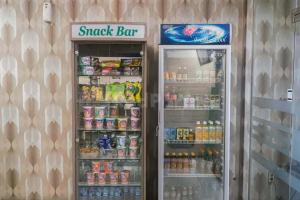 a snack bar refrigerator with its doors open with drinks at Deli Homestay near DeliPark Mall Medan RedPartner in Medan