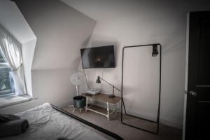- une chambre avec un lit et un bureau avec un miroir dans l'établissement Victorian Penthouse with panoramic sea views, à Ilfracombe