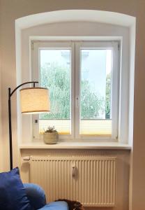 a window in a room with a blue couch and a lamp at Apartment Ida in Berlin