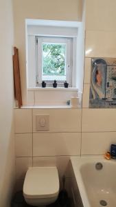 a bathroom with a toilet and a sink and a window at Apartment Ida in Berlin