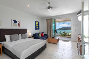 a bedroom with a bed and a view of the ocean at Waterview Airlie Beach in Airlie Beach