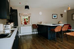 a kitchen with a counter and some chairs in it at The Stables Apartment at Cefn Tilla Court, Usk in Usk