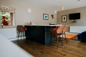 a kitchen with a bar and stools in a room at The Stables Apartment at Cefn Tilla Court, Usk in Usk