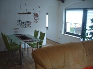 ein Wohnzimmer mit einem Tisch, Stühlen und einem Sofa in der Unterkunft Ferienwohnung Auris in Cranzahl