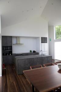 a kitchen with a wooden table and a wooden floor at Furano Peak in Furano
