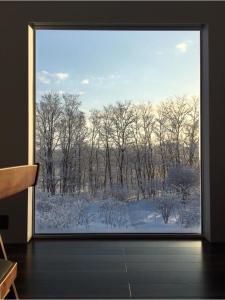 a large window with a view of a snow covered forest at Furano Peak in Furano