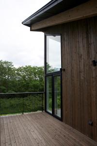 een huis met een glazen deur op een terras bij Furano Peak in Furano