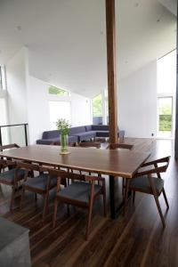 a dining room with a wooden table and chairs at Furano Peak in Furano