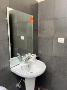 ein Bad mit einem Waschbecken und einem Spiegel in der Unterkunft Retreat Holiday Homes, Twin Chalets at Sparsh Resorts and Chalets, Karjat in Karjat
