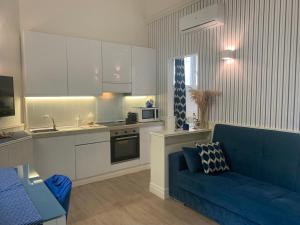 a living room with a blue couch and a kitchen at Perla Blu in Viareggio
