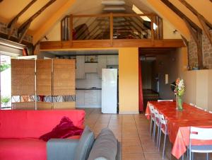 een woonkamer met een rode bank en een keuken bij Maison de 4 chambres avec piscine privee jardin clos et wifi a Pierrefiche in Pierrefiche