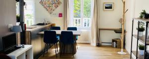 uma cozinha com uma mesa e cadeiras azuis num quarto em CLINT HOUSE - Appartement "l'Île aux Moines" em Perros-Guirec