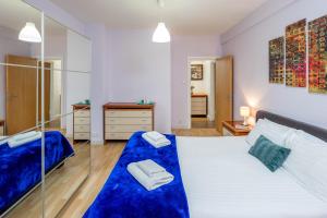 - une chambre dotée d'un grand lit avec des draps bleus dans l'établissement ALTIDO 2-bed flat near Notting Hill, à Londres