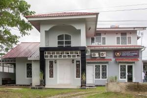 una casa blanca con techo rojo en Zazadior Residence Syariah near Pantai Padang Mitra RedDoorz, en Padang