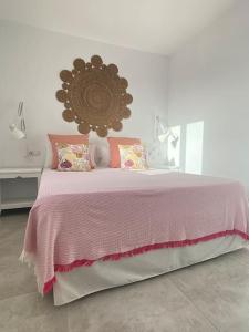 una camera con un letto e una coperta rosa di La Casa de las Hespérides a Morro del Jable