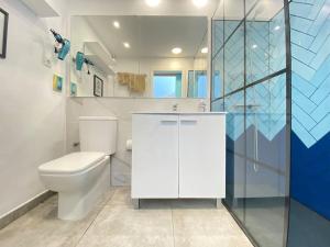 bagno bianco con servizi igienici e doccia di La Casa de las Hespérides a Morro del Jable