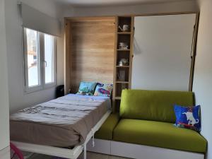 ブルゴスにあるApartamento Martinez del Campoの小さなベッドルーム(ベッド1台、緑の椅子付)