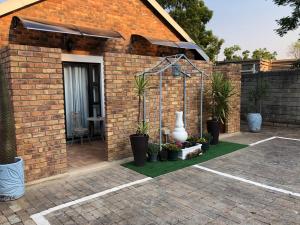 a brick building with plants and a patio at URRR Casa on Msasa in Randburg
