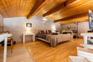 sypialnia z łóżkiem i drewnianym sufitem w obiekcie Maison Gaillan Medoc w mieście Gaillan-en-Médoc