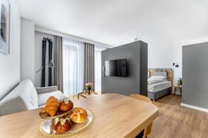 a living room with a table with a plate of bread at Apart House, Tylna 20 in Zielona Góra