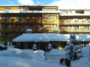 um edifício coberto de neve em frente a um edifício em Hotel La Villa em La Villa
