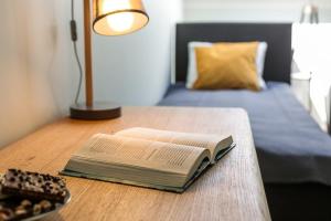 an open book on a table with a bed at Luxury Apartments Old Town Topolowa in Kraków