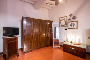 a room with a large wooden cabinet and a television at Angolo Della cei in Terricciola