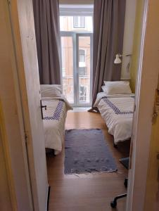 two twin beds in a room with a window at Edith Cavell10 Lisbon Guest House in Lisbon