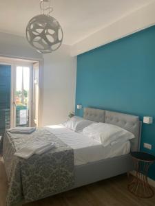 um quarto com uma cama com uma parede azul em Suite Riviera 84 em Nápoles