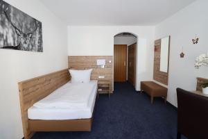 - une chambre à l'hôpital avec un lit et un bureau dans l'établissement Hotel Garni Café Räpple, à Bad Peterstal-Griesbach