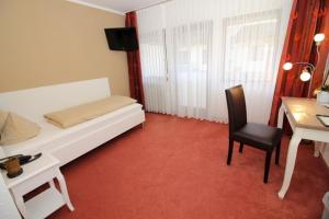 - une chambre avec un lit, une table et une chaise dans l'établissement Hotel Garni Café Räpple, à Bad Peterstal-Griesbach