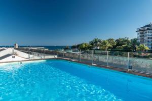 a swimming pool with the ocean in the background at Pestana Cidadela Cascais - Pousada & Art District in Cascais