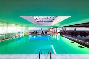 a swimming pool in a building with a green ceiling at Pestana Cidadela Cascais - Pousada & Art District in Cascais