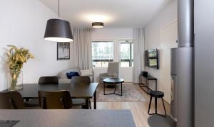 eine Küche und ein Wohnzimmer mit einem Tisch und Stühlen in der Unterkunft Holiday Club Vierumäki Apartments in Vierumäki